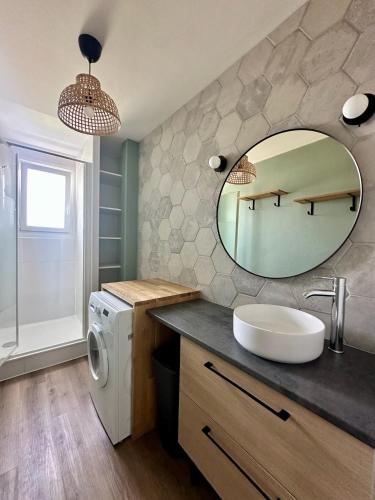 une salle de bain avec un lavabo et un miroir dans l'établissement L intemporel, à Saint-Sébastien-sur-Loire