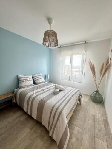 - une chambre avec un grand lit et une lampe pendant dans l'établissement L intemporel, à Saint-Sébastien-sur-Loire