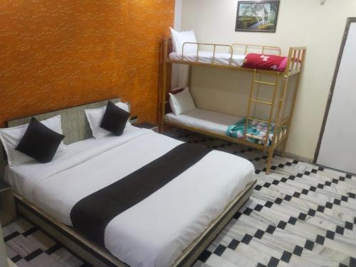 a bedroom with a bed and a bunk bed at HOTEL HAYAT RESIDENCY in Jaipur