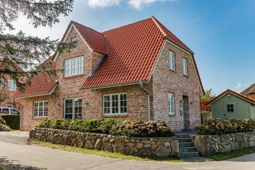 a brick house with a red roof at Landhaus John in Oldsum