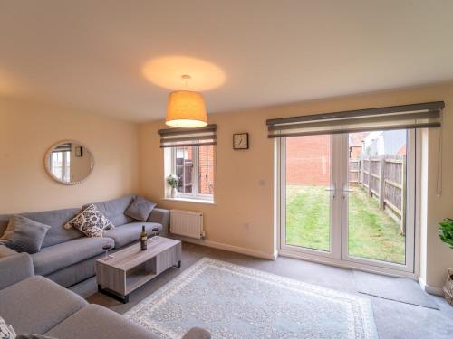 a living room with a couch and a large window at Shop & Stay at Bicester Village near our 3 Bed Home Pass the Keys in Bicester