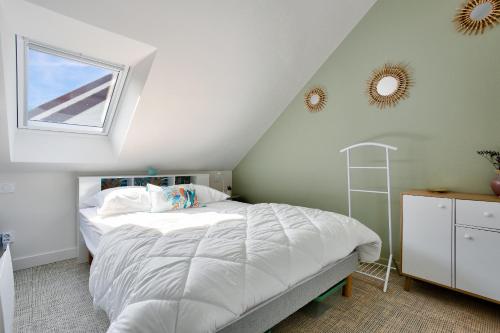 une chambre avec un lit blanc et une fenêtre dans l'établissement 250m de la plage - Studio pour 2 - Balcon, à Dinard