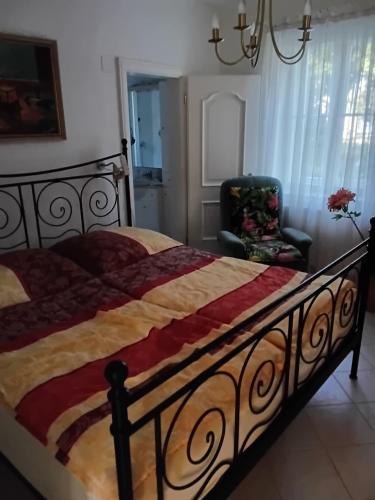 a bedroom with a large bed and a chair at Gästehaus Leutner in Burgau