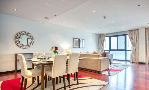 a dining room with a table and a couch at Luxury Holiday Home, Spacious 1 bedroom, Burj Alarab full ocean view, located in Anantara the palm, Palm Jumeirah, Dubai in Dubai