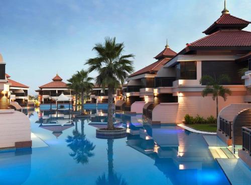 a hotel with a pool in front of some buildings at Luxury Holiday Home, Spacious 1 bedroom, Burj Alarab full ocean view, located in Anantara the palm, Palm Jumeirah, Dubai in Dubai