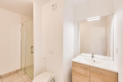 une salle de bain avec toilettes, lavabo et miroir dans l'établissement Appart pour 2 - 50 m de la plage du Val André, à Pléneuf-Val-André