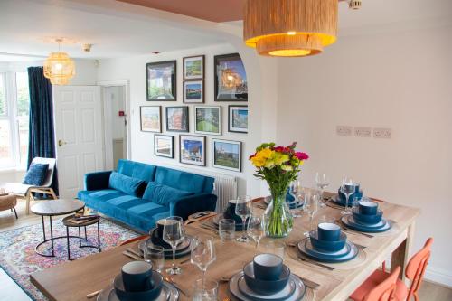 a living room with a table and a blue couch at Spacious Home, Walk to City Centre & Free Parking in Worcester
