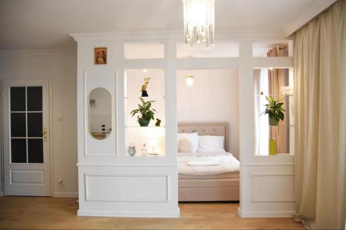 a white room with a bed with a mirror at Mieszkanie Central Park in Ciechanów