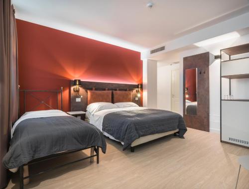 a bedroom with two beds and a red wall at Rivalta Life Style Hotel in Salò