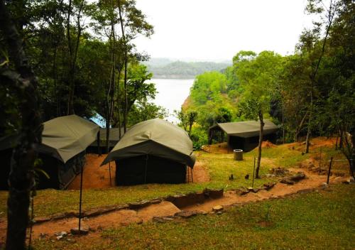 a group of tents with a lake in the background at Belihuloya Adventure Camp By Eco Team in Belihul Oya