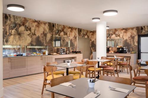 a restaurant with tables and chairs and a kitchen at Acta Pirámides in Madrid