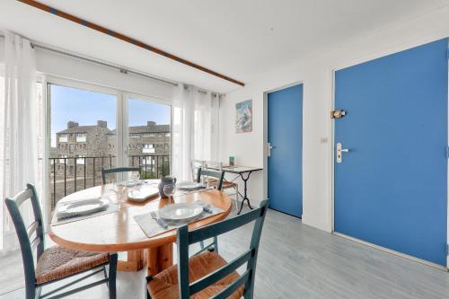 une salle à manger avec une table et des chaises et un balcon dans l'établissement Appart à 100m des plages du Fogeo et Kerjouanno, à Arzon