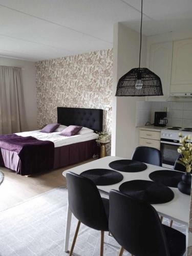a bedroom with a bed and a table and chairs at Ahtinhovi in Ylivieska