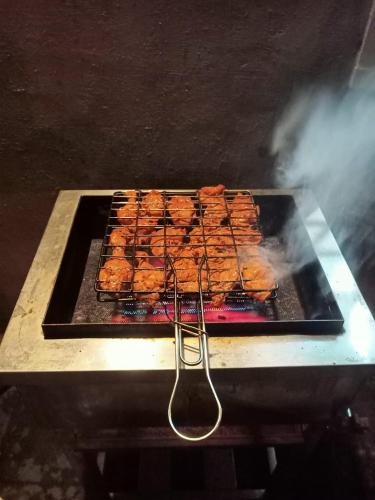a grill with a bunch of food on it at Pear Mount Farm House in Kodaikānāl