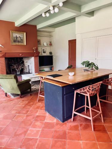 une cuisine avec une table et des chaises dans une pièce dans l'établissement Charmant appartement en rdc dans château avec parc, à Villefranche-de-Lauragais