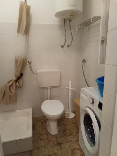 a bathroom with a toilet and a washing machine at Vake in Herceg-Novi