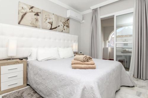 ein Schlafzimmer mit einem weißen Bett und einem Handtuch darauf in der Unterkunft Private 2 Bedroom Flat in VIME La Reserva de Marbella in Sitio de Calahonda