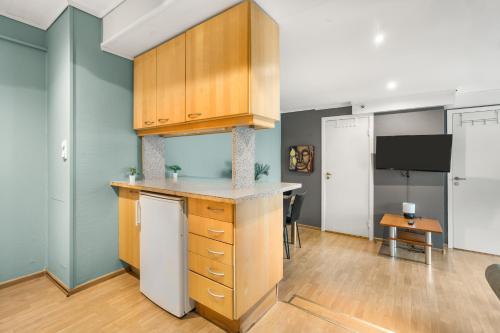 a kitchen with wooden cabinets and a counter top at BUDGETEL- Kong Oscarsgate 44 in Bergen