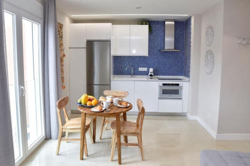 a kitchen with a table with a bowl of fruit on it at La Sirena Playa A in Puerto de la Cruz