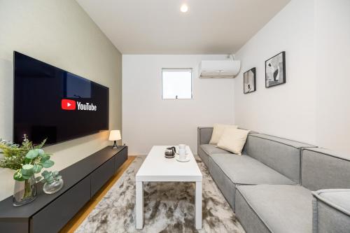 a living room with a couch and a tv at Modern Japan 東京浅草 east in Tokyo
