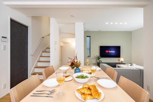 a dining room with a table with bread and wine glasses at Modern Japan 東京浅草 east in Tokyo