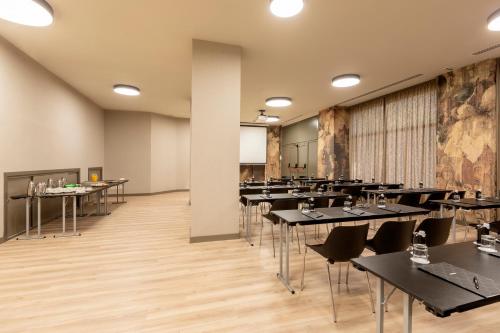 a dining room with tables and chairs and a wall at Acta Pirámides in Madrid