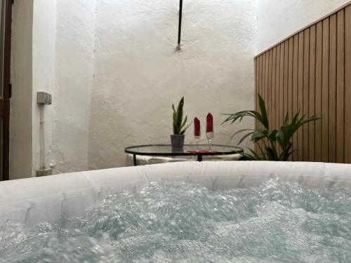 una bañera llena de agua junto a una mesa en Belmonte Rooms, en Córdoba