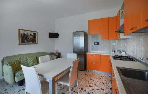 a kitchen with orange cabinets and a white table and chairs at 4 Bedroom Cozy Home In Reggio Calabria in Reggio Calabria