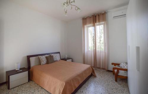 a bedroom with a bed and a window and a chair at 4 Bedroom Cozy Home In Reggio Calabria in Reggio Calabria