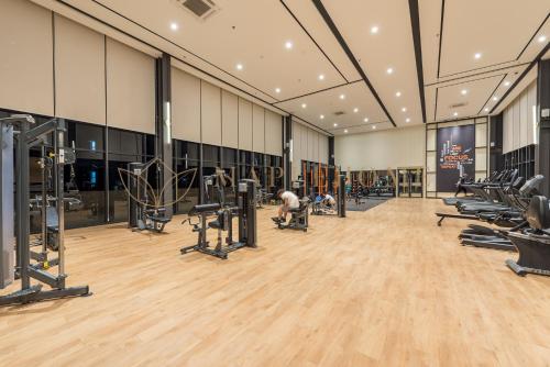 a gym with rows of treadmills and machines at Mossaz Premier Suites Damansara in Kampong Bukit Lanjan