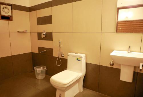 a bathroom with a toilet and a sink at Aditi HOMESTAY in Kalpetta