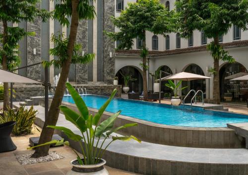 a pool in a hotel with trees and umbrellas at Radisson Lagos Ikeja in Lagos