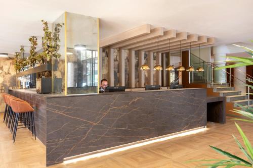 a man sitting at a counter in a room with a lobby at Acta Pirámides in Madrid