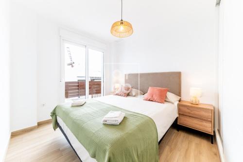 a bedroom with a bed with a green blanket at Villa Bienvida luxury and well-being by OYOOSTAYS in Orihuela