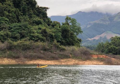 a person in a yellow kayak in a lake at Belihuloya Adventure Camp By Eco Team in Belihul Oya