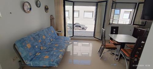 a living room with a blue couch and a table and a table and a table at Hotel Brisa del Mar in O Grove