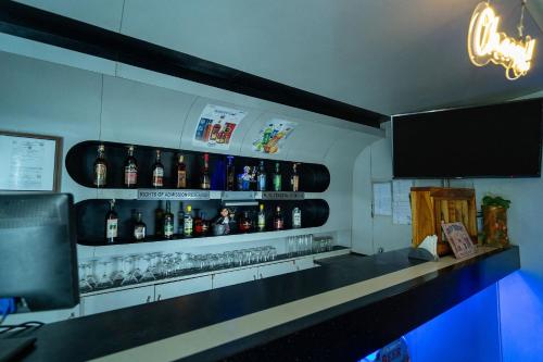 a bar with a bunch of alcohol bottles on the wall at MGM Vailankanni in Velānganni