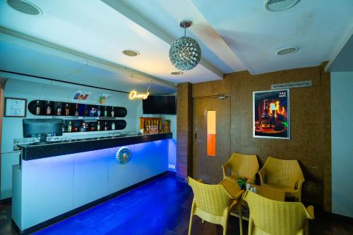 a bar with yellow chairs and a blue counter at MGM Vailankanni in Velānganni