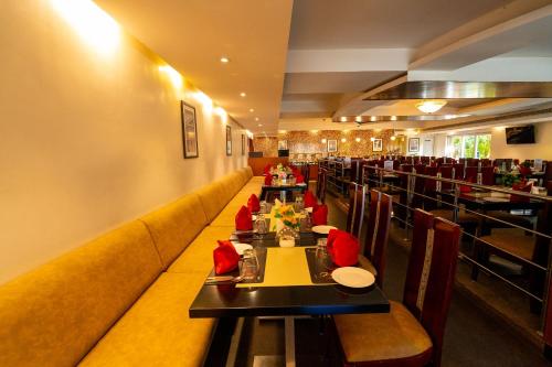a dining room with tables and chairs in a restaurant at MGM Vailankanni in Velānganni