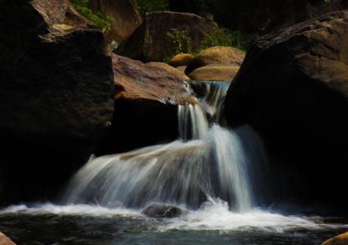 a close up of a waterfall in a river at Belihuloya Adventure Camp By Eco Team in Belihul Oya