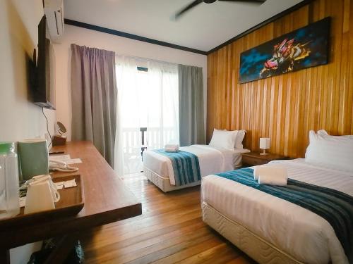 a hotel room with two beds and a window at Mamutik Island Lodge in Kota Kinabalu