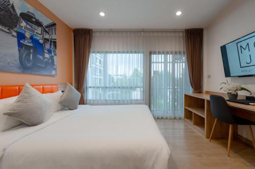 a hotel room with a bed and a desk and a computer at Moji Don Mueang Airport Hotel - Bangkok in Bangkok