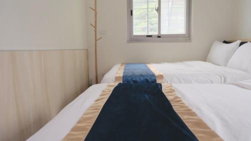 two beds sitting next to each other in a room at 九份山嶼海 in Jiufen