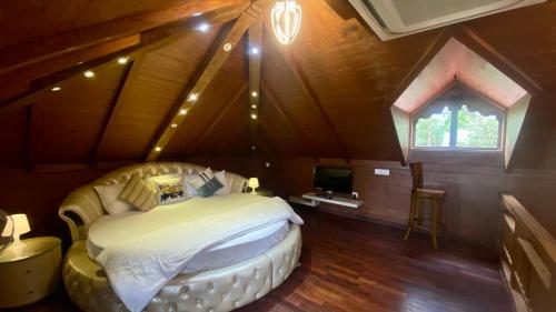 a bedroom with a large bed in a attic at Willo stays The Metro Landsend Beach Resorts in Kannur