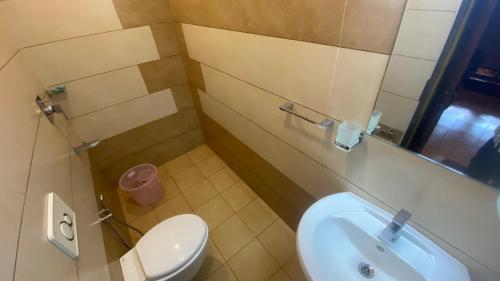 a bathroom with a white toilet and a sink at Willo stays The Metro Landsend Beach Resorts in Kannur