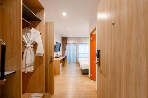 a hotel room with a robe hanging on a closet at Moji Don Mueang Airport Hotel - Bangkok in Bangkok
