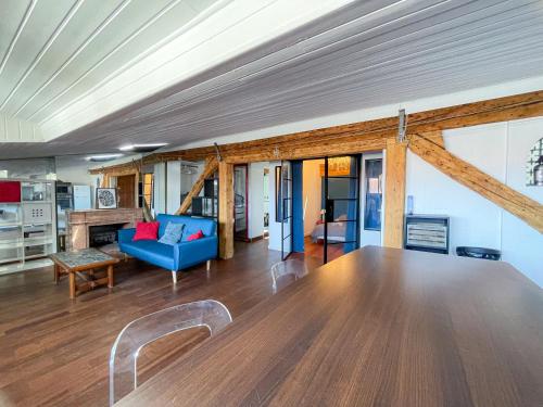 - un salon avec un canapé bleu et des plafonds en bois dans l'établissement La Cachette - Logement Atypique Sous Les Toits, à Toulouse