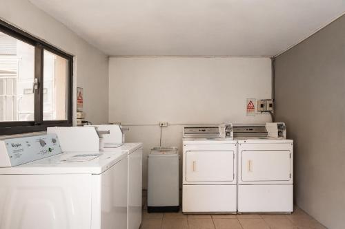 a laundry room with white appliances and a window at The Riverside Hotel Hengchun in Hengchun
