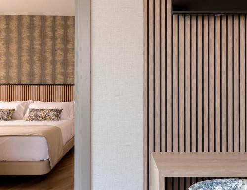 a bedroom with a bed and a wall at Acta Pirámides in Madrid