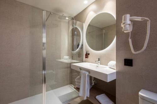 a bathroom with a shower and a sink and a mirror at Acta Pirámides in Madrid